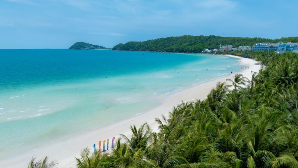 White sandy beach with turquoise water and palm trees on Phu Quoc Island, Vietnam — tropical coastline view