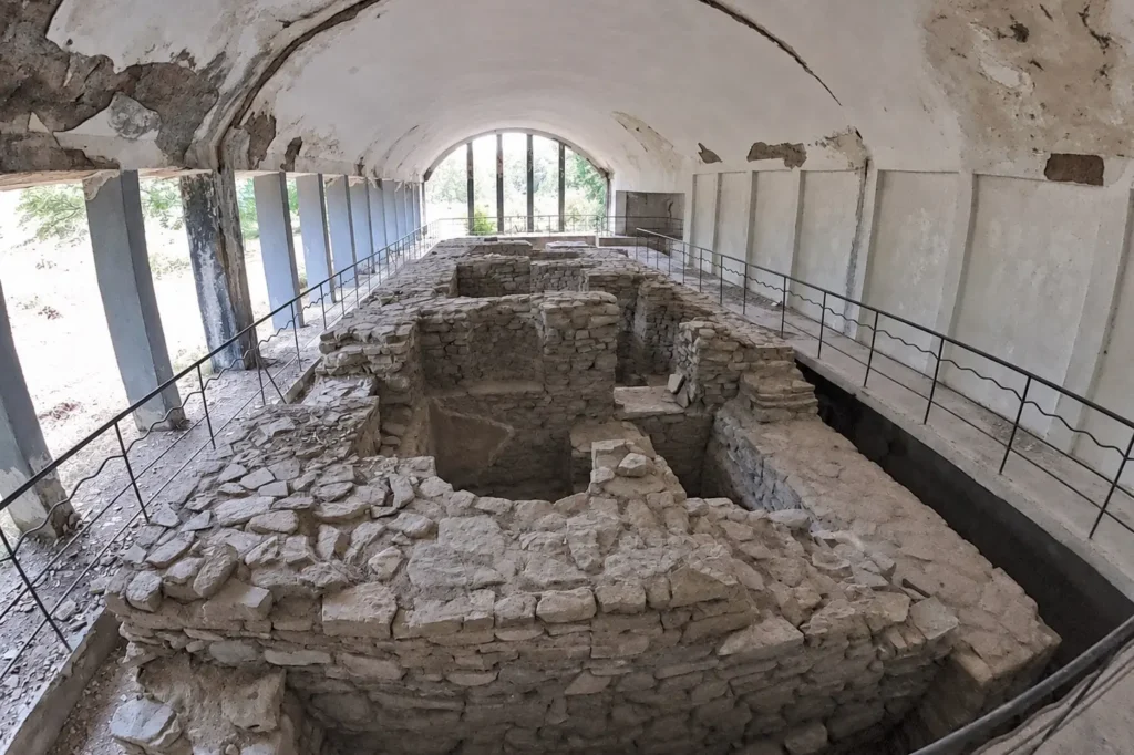 Excavated stone rooms of the Roman-style bathhouse beneath a protective shelter at Armaziskhevi